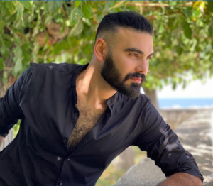 Theodoros Kalotinis leaning on a divider at a park looking in the distance.