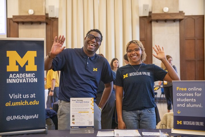 Academic Innovation staff members in block M shirts smiling and waving
